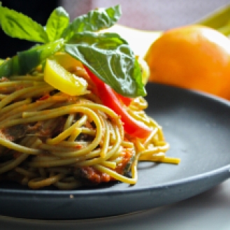 pasta-with-vegetable-dish-on-gray-plate-beside-tomato-fruit-769969