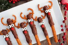 Cute Christmas reindeer chocolate dipped pretzel rods, above on a white serving plate